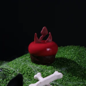 Devil Halloween cake petit gateaux. Red Cake, Black Background, Green Grass